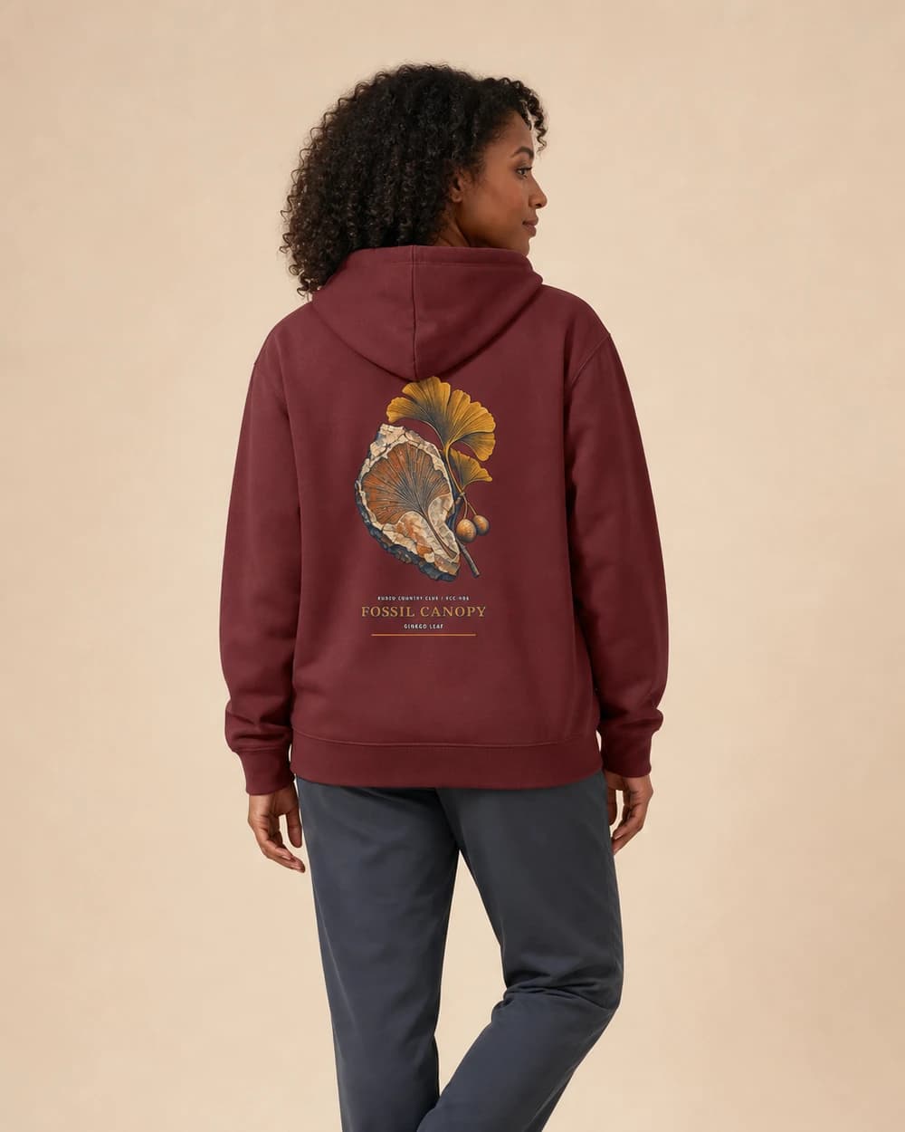 Adult wearing the Fossil Canopy hoodie in Maroon, back view