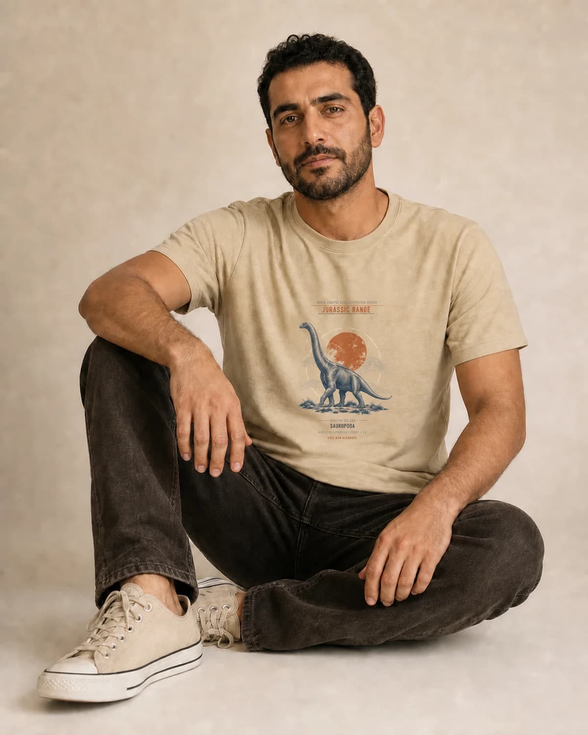 Adult wearing the Jurassic Range tee in Soft Cream