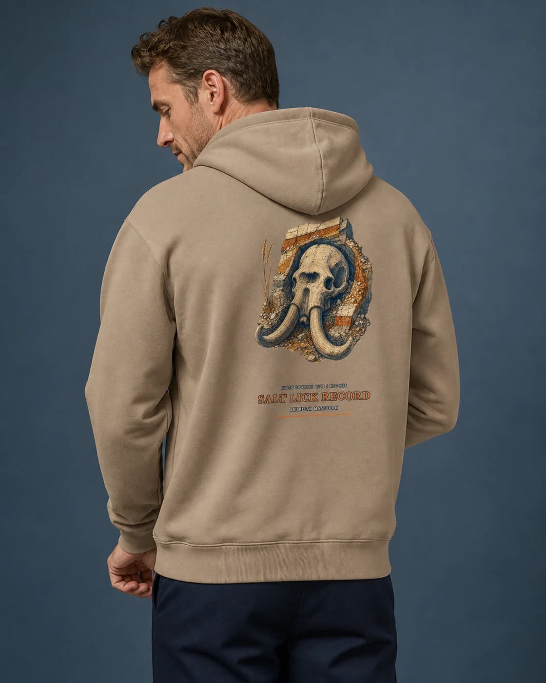 Adult wearing the Salt Lick Record hoodie in Sand, back view
